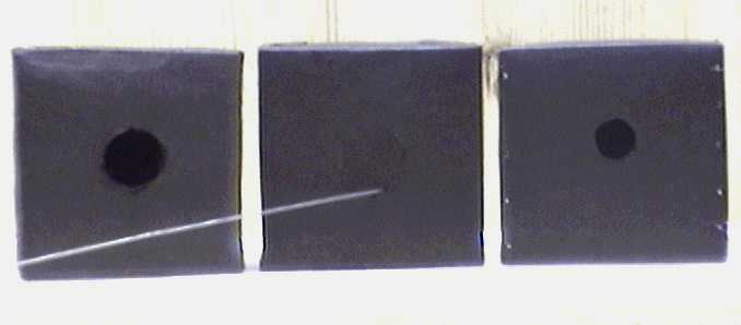 drei schwarze Würfel mit Stricknadel